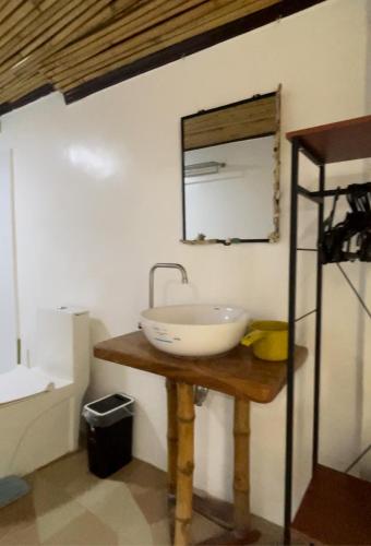 a bathroom with a sink and a mirror on a table at Tabskie’s Homestay in Catarman