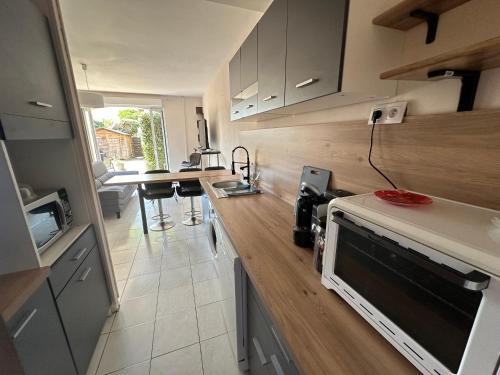 une cuisine avec un comptoir et une table à l'intérieur dans l'établissement Mini Villa T3 duplex, à Borgo
