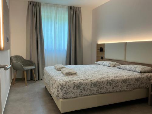 a bedroom with a bed with towels on it at Villa Regina - Lake Ledro Apartments in Ledro