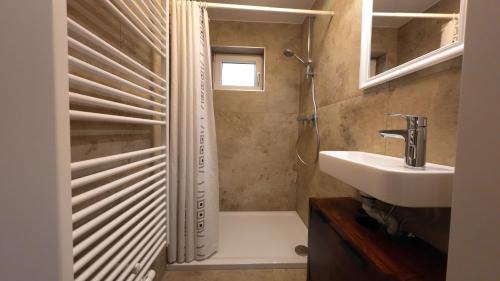 een badkamer met een bad, een wastafel en een douche bij Ferienwohnung Zirbenzapfen - Auszeit in den Seetaler Alpen in Judenburg