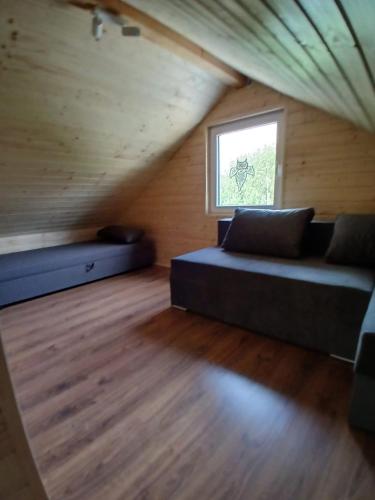 a room with a couch and a window in a attic at Domki na Szlaku in Jarnołtówek