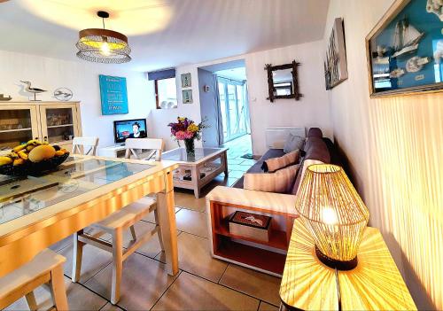 un salon avec un canapé et une table dans l'établissement La Cabane d'Aselia - petite Maison de Pêcheur, à Le Portel