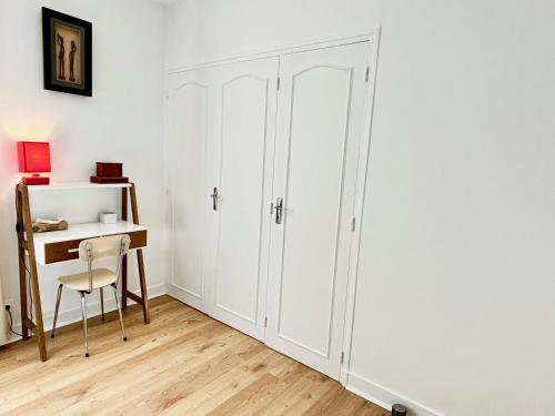 - un placard blanc dans une chambre avec un bureau et une chaise dans l'établissement La Forêt - Jardin, Forêt de Fontainebleau, à Bois-le-Roi