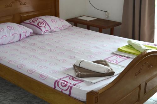a large bed with pink and white sheets and pillows at Tanja Terrace Appartments Dobre Vode in Dobra Voda