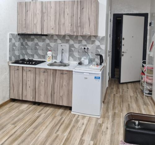 a kitchen with wooden cabinets and a white refrigerator at Black Sea Line in Gonio
