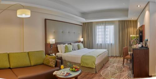 Habitación de hotel con cama y sofá en Ramee Rose Hotel en Manama