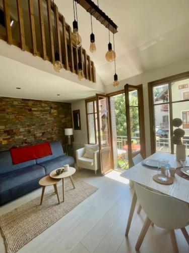 un salon avec un canapé bleu et une table dans l'établissement Le Canal - Nice Studio on the Venice of the Alps, à Annecy