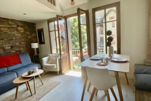 un salon avec une table et un canapé bleu dans l'établissement Le Canal - Nice Studio on the Venice of the Alps, à Annecy