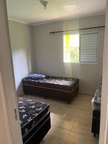 a room with two beds in it with a window at Chácara LM in São Roque