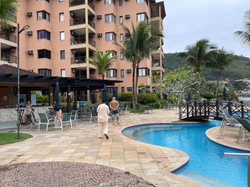 a man walking by a pool at a hotel at Piscina, Mar e estilo em Angra dos Reis in Angra dos Reis