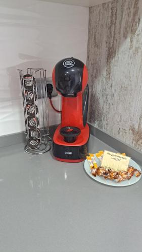 a red coffee maker and a plate of food on a counter at Lo de Joel in Els Muntells