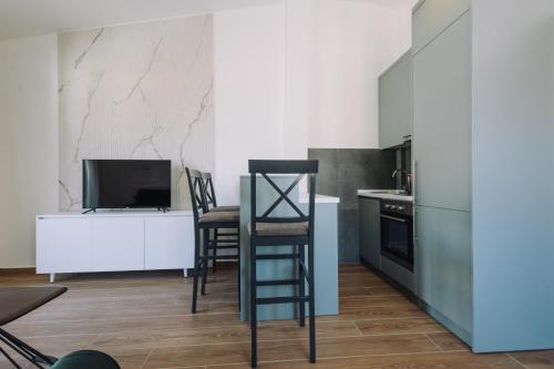 a kitchen with a counter and two chairs and a television at Barba Apartments in Ulcinj