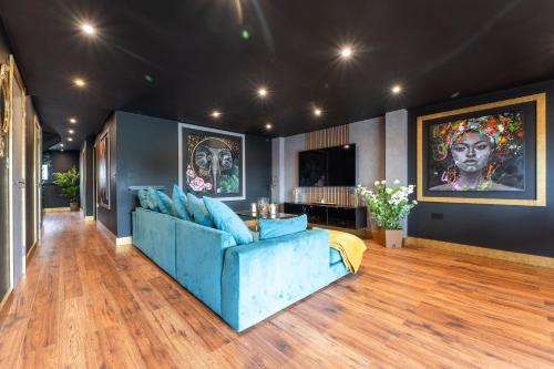 a living room with a blue couch and paintings on the wall at Samana Vayu in Poole