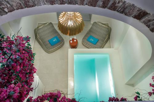 a hallway with a mirror and some purple flowers at La Madeleine Oia in Oia