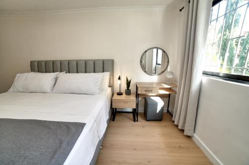 a bedroom with a bed and a desk with a mirror at Casa en Laureles- Excelente Ubicación! in Medellín