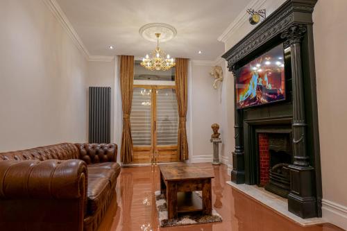 a living room with a couch and a fireplace at Hyacinth Apartments - Central Luxury Brighton in Brighton & Hove