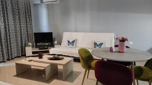 salon z kanapą i stołem z krzesłami w obiekcie Summertimes w Aleksandropolis