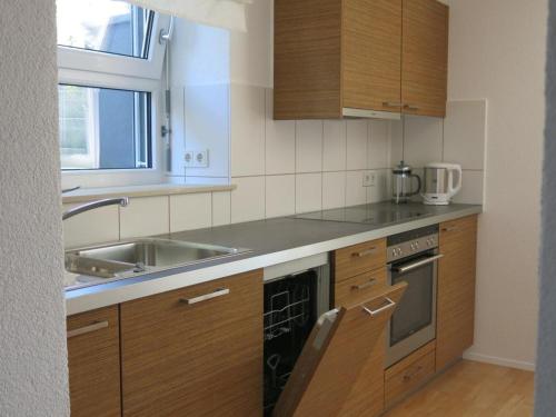 a kitchen with wooden cabinets and a sink at Zentrales 2-Zimmer Apartment in Tübingen