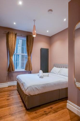 a bedroom with a large bed and a window at Hyacinth Apartments - Central Luxury Brighton in Brighton & Hove