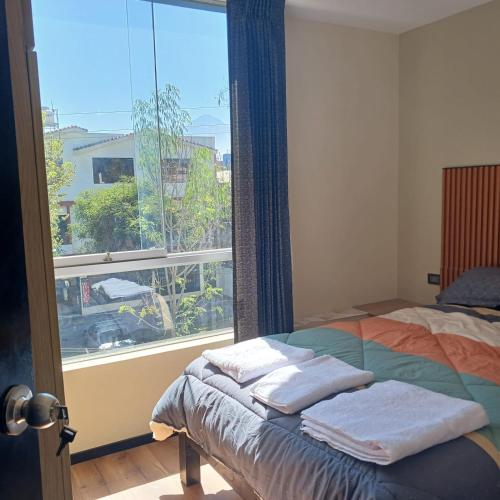 a bedroom with a bed and a large window at Aparments Av La Paz in Arequipa