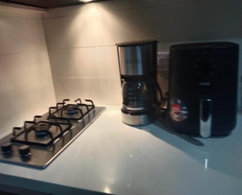 a kitchen counter with a stove and a coffee maker at Céntrico Familiar Vive y disfruta Medellín 107 in Medellín