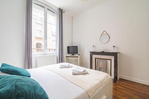 a bedroom with a bed and a fireplace at Le Charmant Bacquenois in Reims
