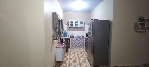 a kitchen with a refrigerator and a tile floor at Casa de temporada SONHO DE ALTER in Alter do Chao