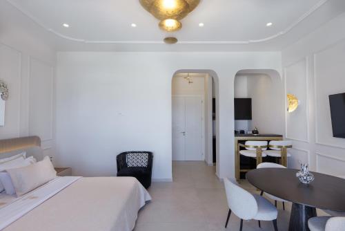 a hotel room with a bed and a table and chairs at La Madeleine Oia in Oia