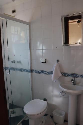 a bathroom with a toilet and a sink and a shower at Camping Pousada Ilha do Mel - Frente ao Mar in Boracéia