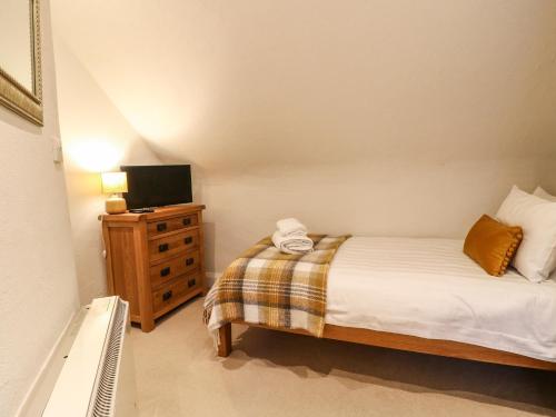 a bedroom with a bed and a tv on a dresser at Dragon Hill Barn in Matlock
