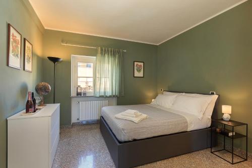 een slaapkamer met een bed met groene muren en een raam bij Casa del Corso in Novi Ligure
