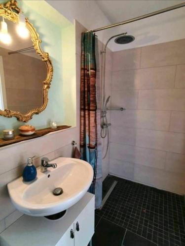 a bathroom with a sink and a shower at Meerzeitraum Ferienwohnung in Neustadt in Holstein