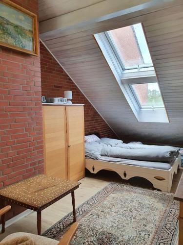 a attic room with a bed and a window at Meerzeitraum Ferienwohnung in Neustadt in Holstein