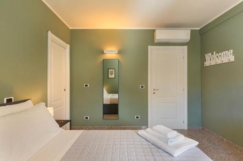 a bedroom with a white bed and a green wall at Casa del Corso in Novi Ligure