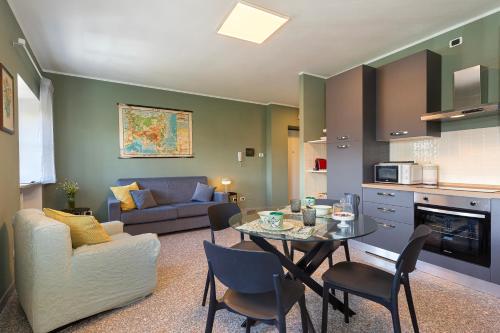 a kitchen and living room with a table and a couch at Casa del Corso in Novi Ligure