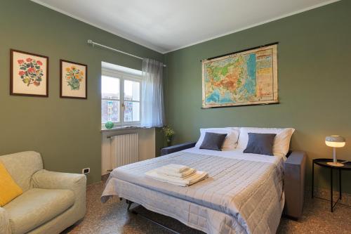 a bedroom with a bed with a couch and a chair at Casa del Corso in Novi Ligure