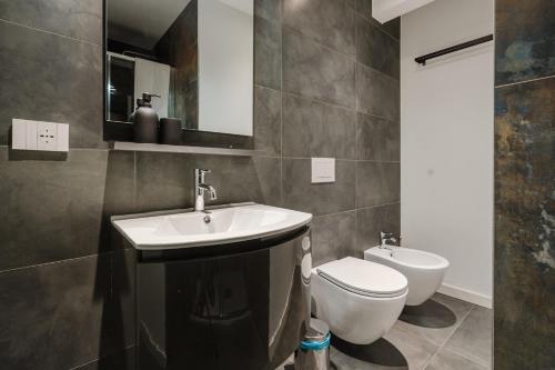 a bathroom with a sink and a toilet and a mirror at Casanova Bluelife in Trieste