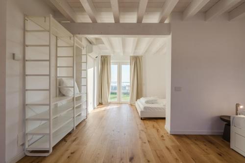 a white bedroom with a bed and a book shelf at Casanova Bluelife in Trieste