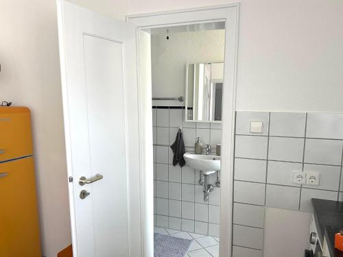 a white bathroom with a sink and a mirror at Apartment W32 in Friedrichshafen