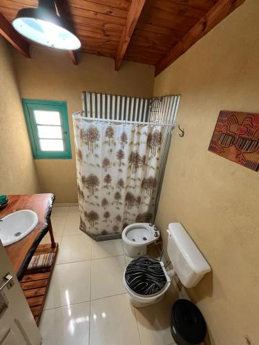 un bagno con un water e una tenda da doccia di cabañas Las cholitas a San Luis