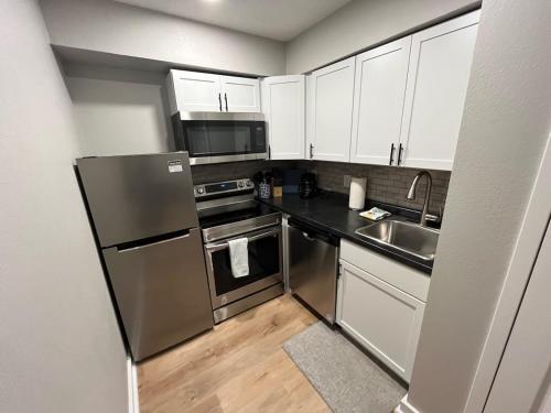 a kitchen with stainless steel appliances and white cabinets at Aksarben Area-Near I80 & UNO in Omaha
