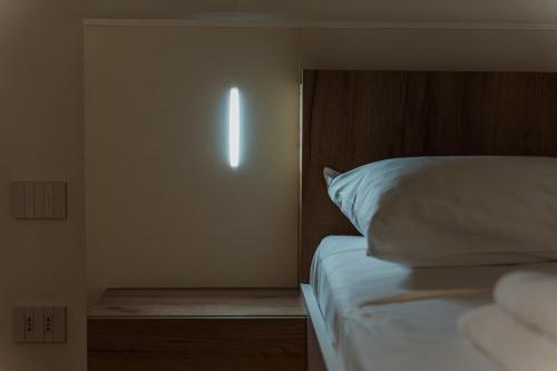 a bedroom with a white bed with a wooden headboard at Casanova Bluelife in Trieste