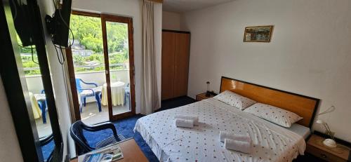 a small bedroom with a bed and a balcony at Pansion 8 ferala in Novigrad Dalmatia