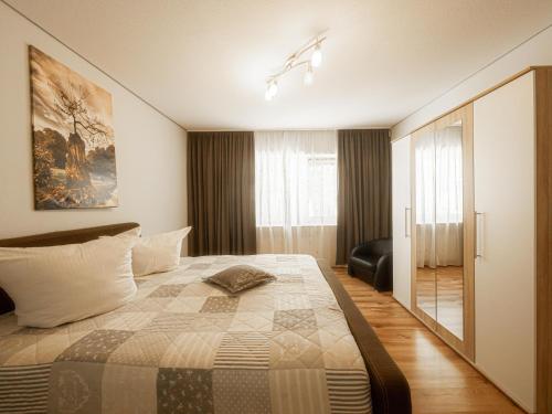 a bedroom with a bed and a chair in a room at Palatium Bad Ems in Bad Ems
