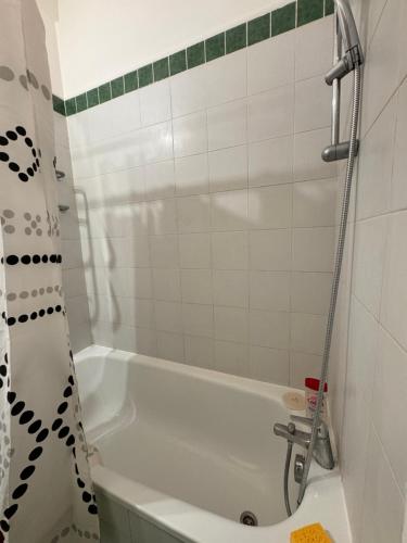 une salle de bain avec une baignoire blanche et une douche dans l'établissement Appartement 2 pièces charmant et paisible vue sur jardin, à Boulogne-Billancourt
