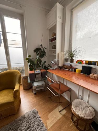 un salon avec un bureau et une chaise dans l'établissement Appartement 2 pièces charmant et paisible vue sur jardin, à Boulogne-Billancourt