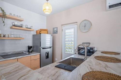 a kitchen with a sink and a stainless steel refrigerator at Cozy Retreat in San Juan in San Juan