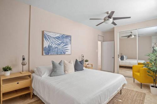 a bedroom with a white bed and a yellow chair at Cozy Retreat in San Juan in San Juan