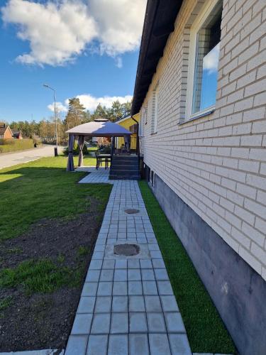 a walkway next to a building with a picnic table at Modernt gästhus på 90 m2 för upp till 8 personer in Västervik