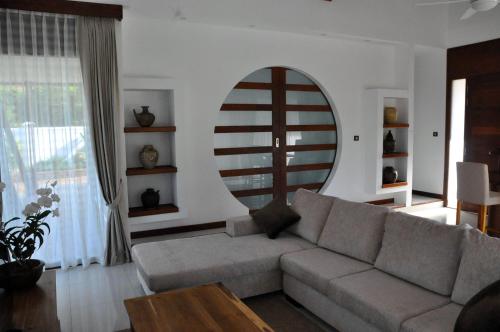 a living room with a couch and a large mirror at Cominsia Lodge in Kep
